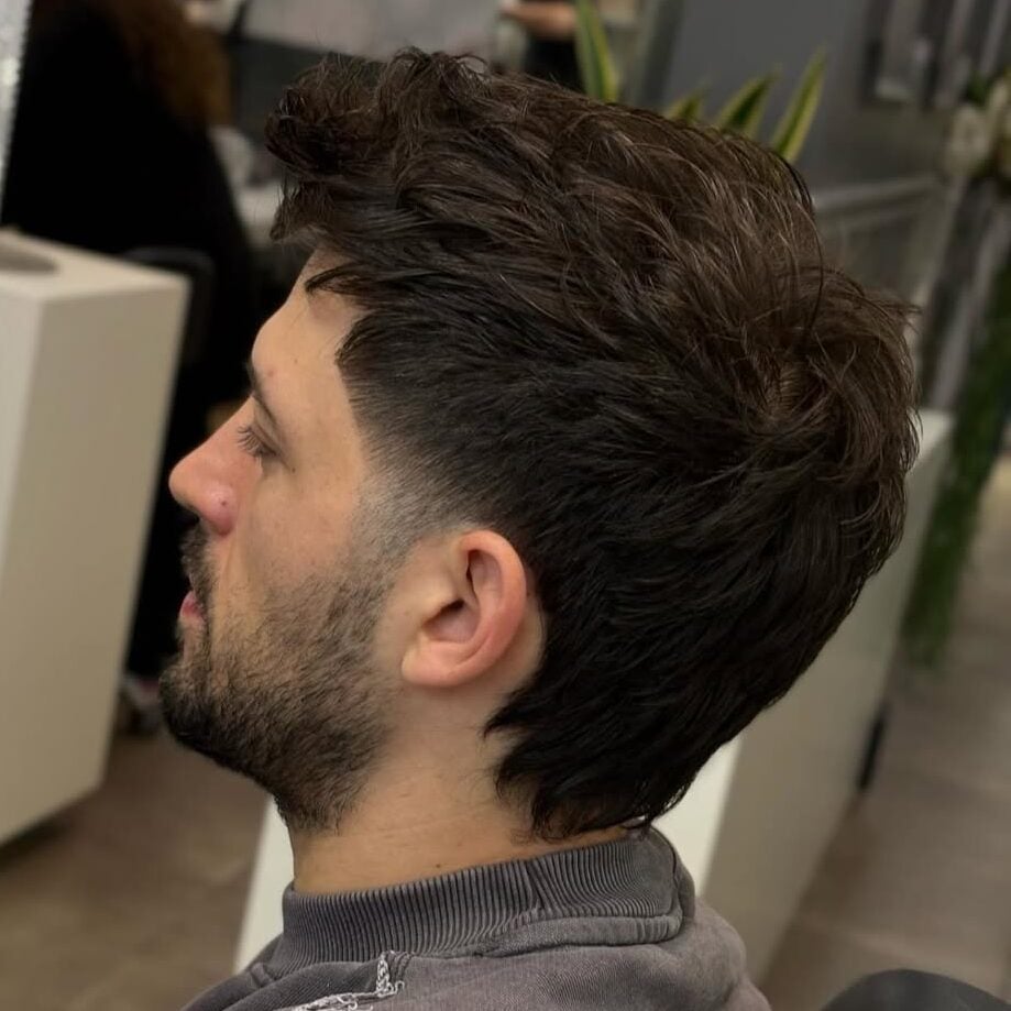 a guy with a shaggy faded haircut